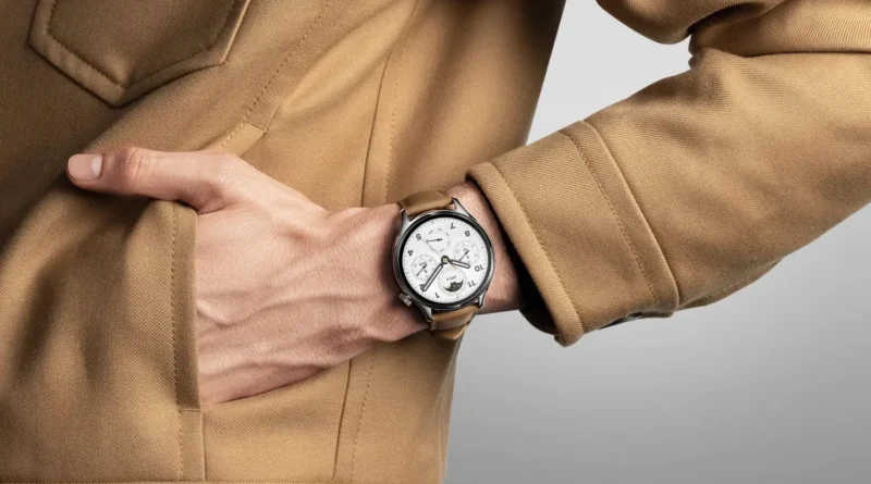 smartwatch Xiaomi na nadgarstku osoby w płaszczu