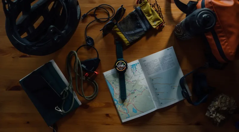 zegarek Suunto Vertical 2 na stole między akcesoriami podróżniczymi