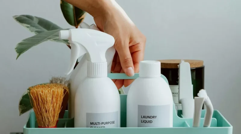 Środki czystości, takie jak detergent i płyn do mycia powierzchni, ułożone w skrzynce.